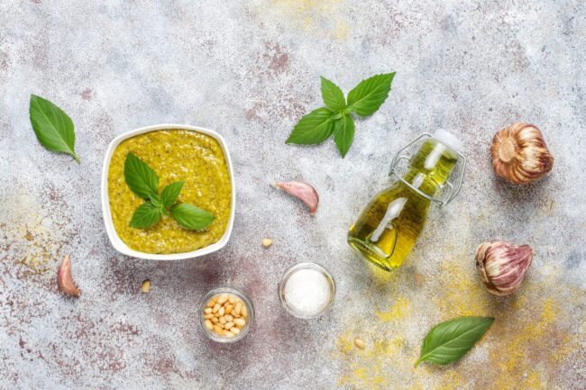 Basil Image of pesto, basil, and garlic illustrates blog: :Which Type of Basil Is Best for Pesto?"