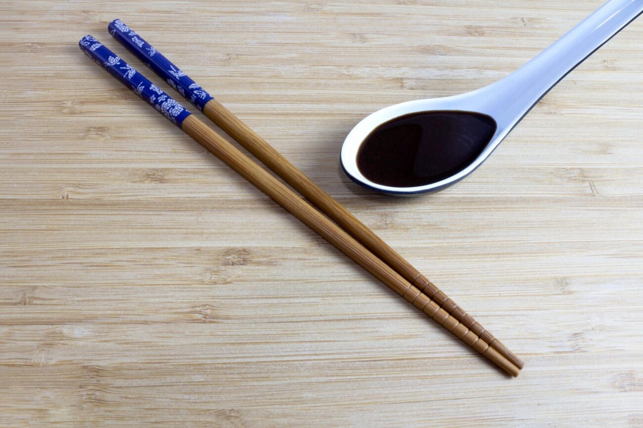 Photo of chopsticks and spoon with teriyaki sauce.
