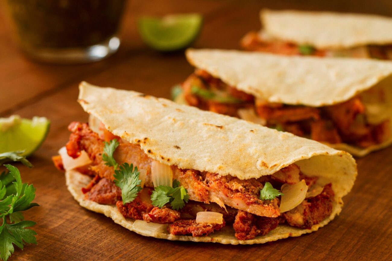 Photo of tacos on wooden board illustrates blog: "4 Interesting Facts About Tacos"