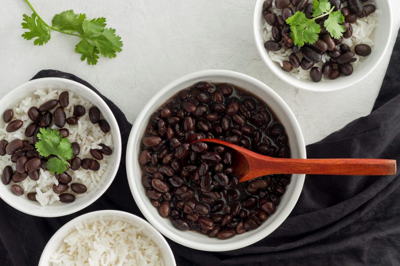 Photo of bowl with black beans and wooden spoon illustrates blog: "Are Black Beans a Vegetable?"