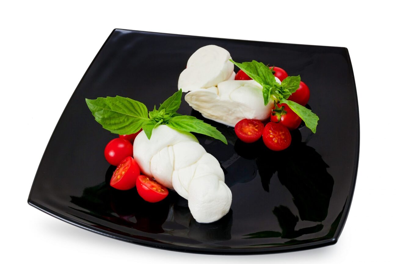 Plate with mozzarella and cherry tomatoes illustrates blog: "Is Mozzarella Made From Cow’s or Goat’s Milk?"