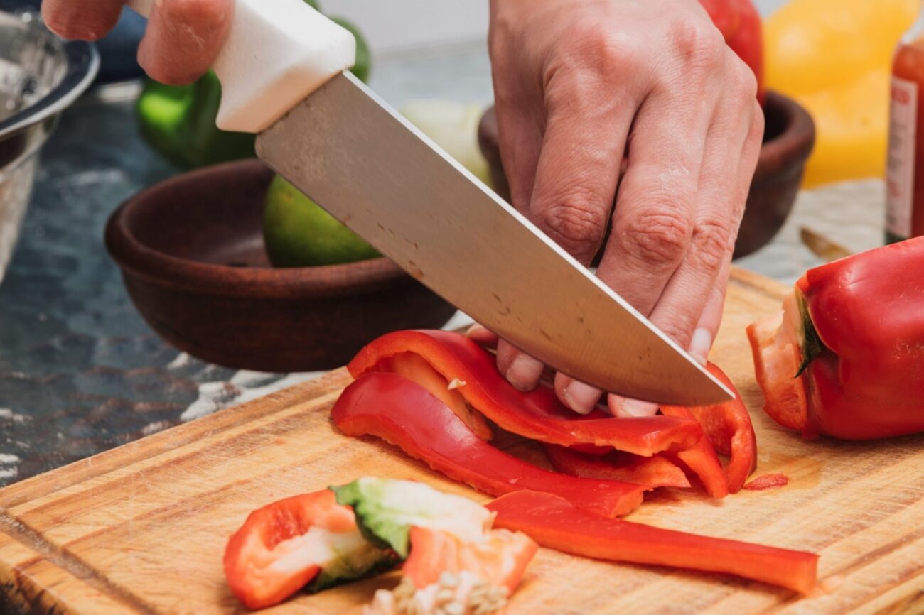KnifeChef Chef cutting peppers illustrates blog "5 Essential Cooking Tools Everyone Needs"