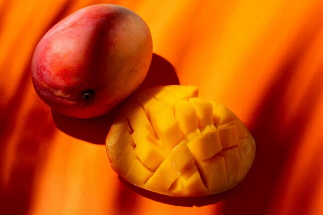 mango-FP Closeup of whole and sliced mango illustrates blog "How To Know if a Mango Is Ripe"