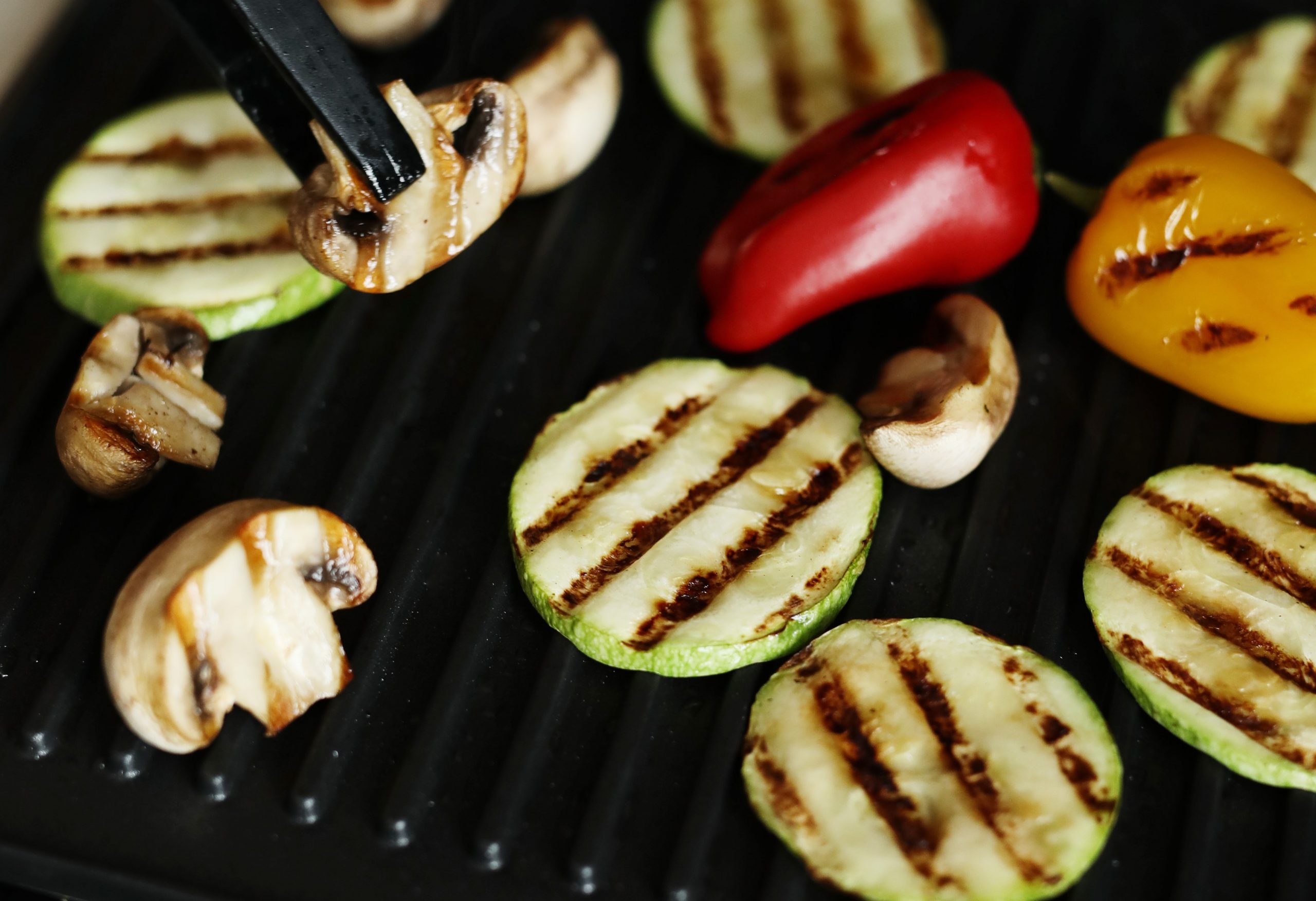 Closeup of person grilling vegeables.