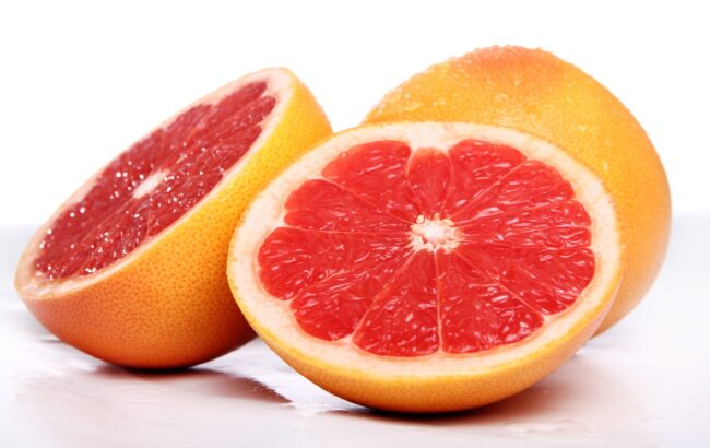 grapefruit-racool_studio Whole grapefruit and grapefruit cut in half illustrate blog "Is Grapefruit Bitter?"