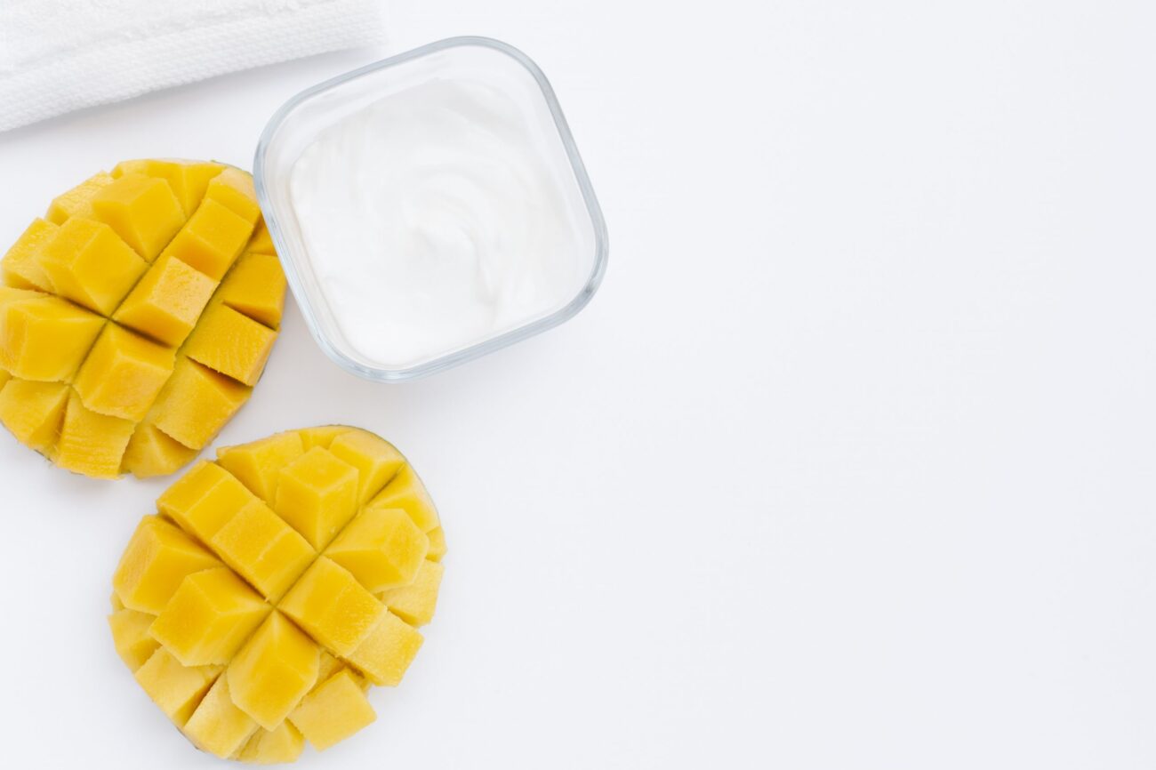 Photo of two sliced mangos by glass cup illustrate blog "Are Mangos High in Fiber?"