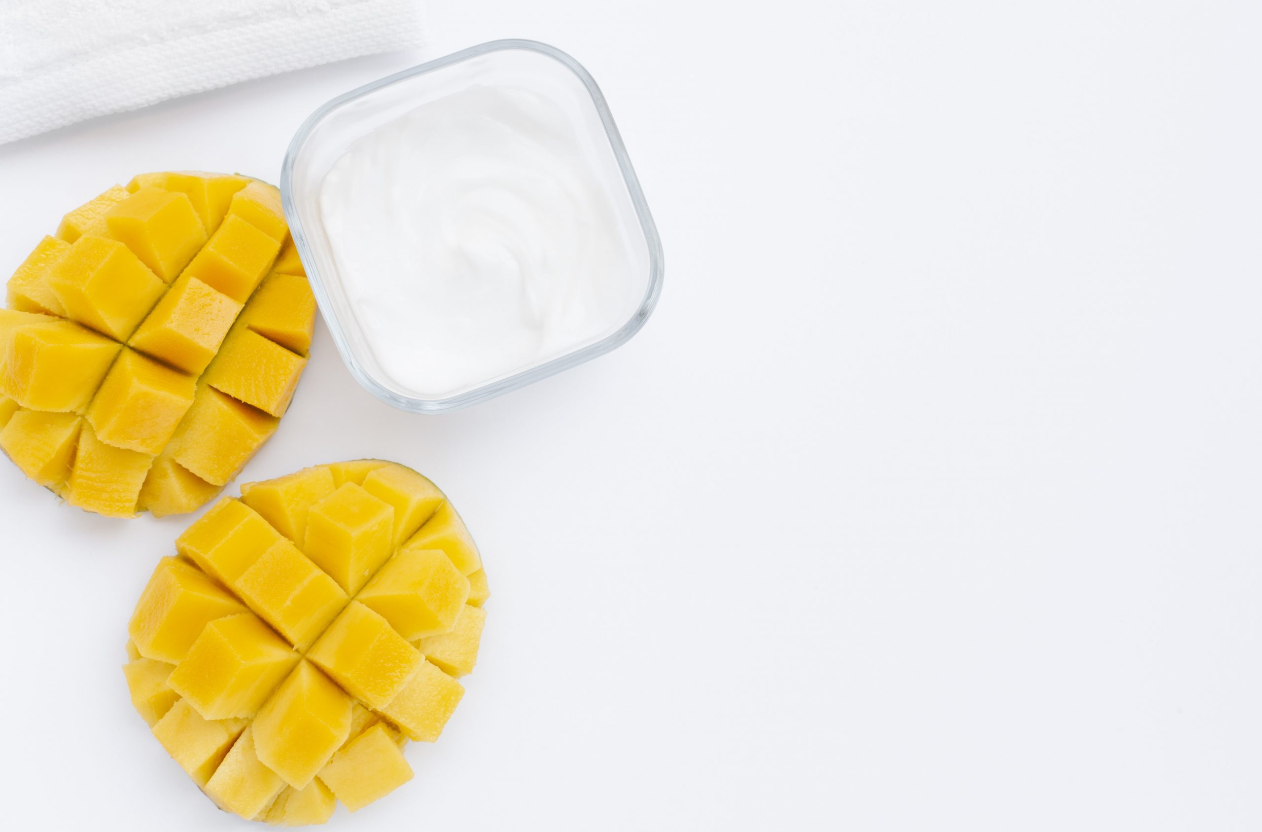 Photo of two sliced mangos by glass cup illustrate blog "Are Mangos High in Fiber?"