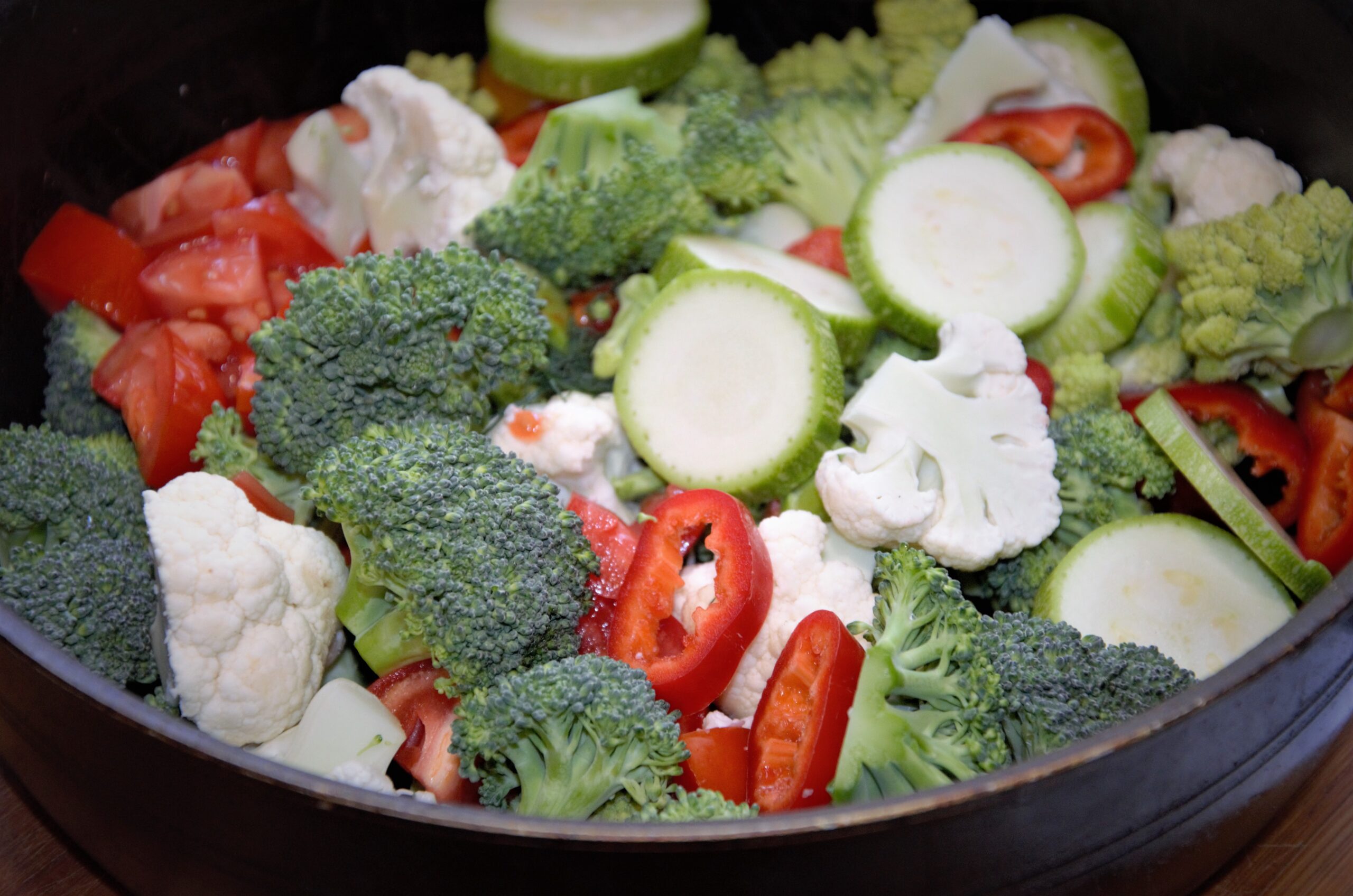 vegetables cut in a frying pan, cauliflower, broccoli, zucchini and tomato, preparation for frying