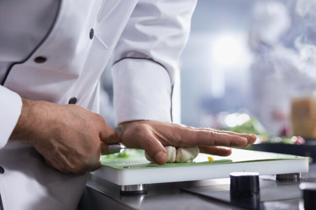 hef preparing allergen-friendly corporate catering dishes in a professional kitchen