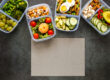 office team eating healthy meal prep containers at modern workspace table with fresh food, salads and balanced meals, natural lighting, realistic professional setting