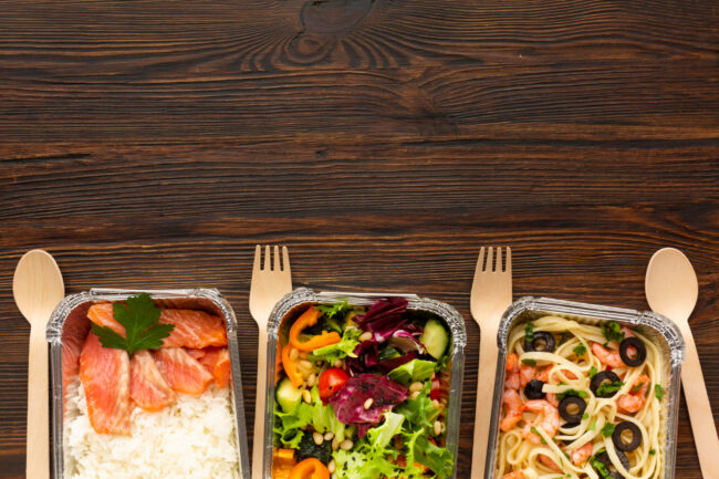 Chef-prepared meals displayed beside packaged office food in a workplace setting
